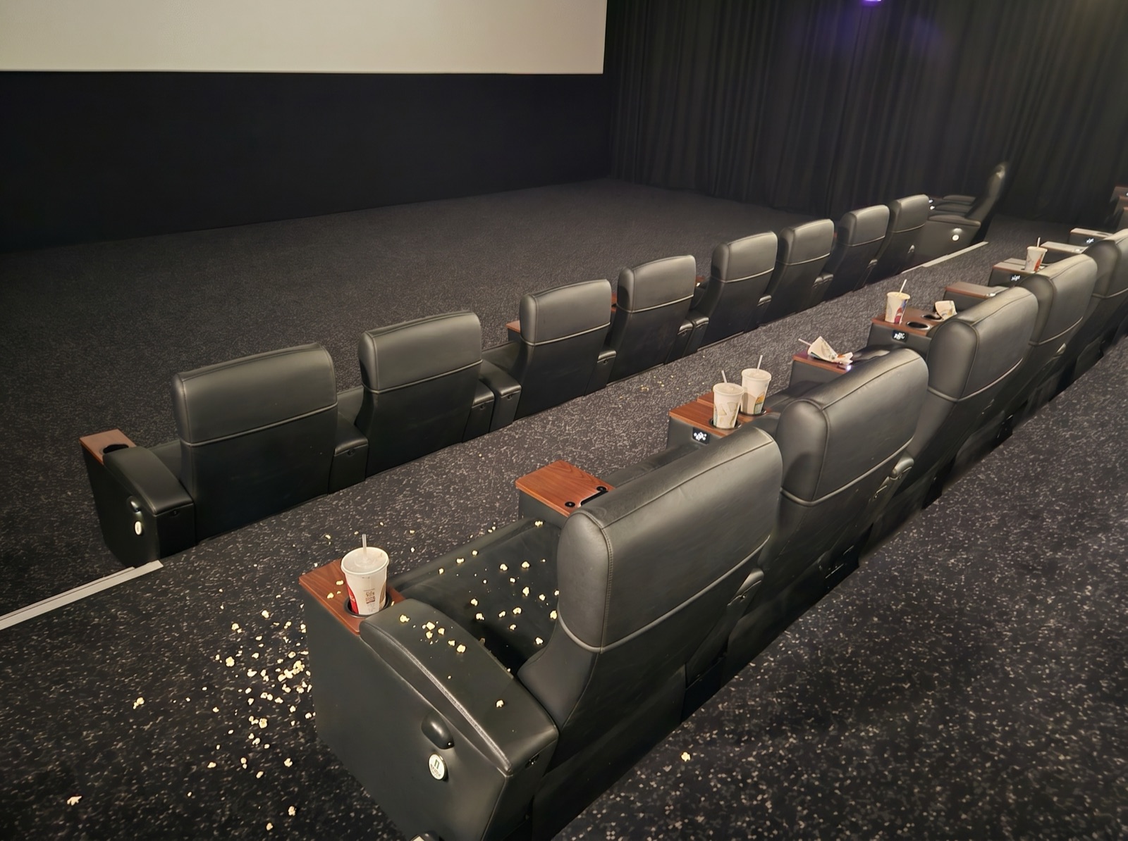 The same cinema seating with popcorn and cups left behind
