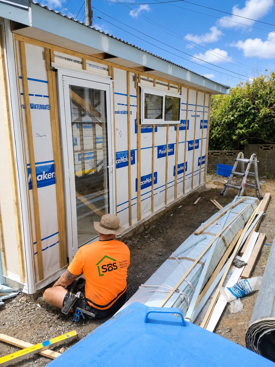 A Supreme Building Services builder at work on a building wrap and framing job